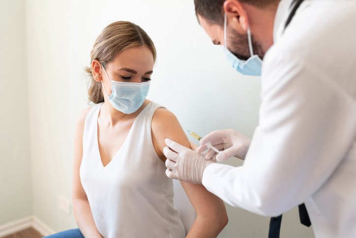 person receiving an immunisation shot in their arm