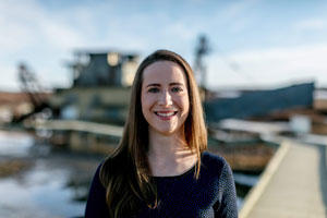 Portrait of Kathryn Sawyer, standing in front of dock, smiling.