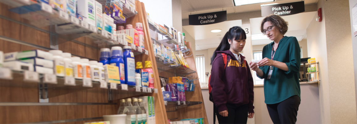 A student talking with a professor inside Pharmacy store