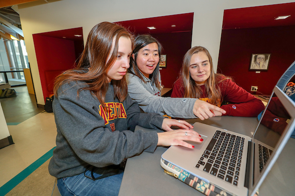 Three students looking at laptop