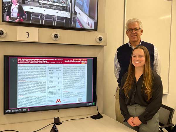Jed Gorlin and Molly Schoephoerster in front of research poster