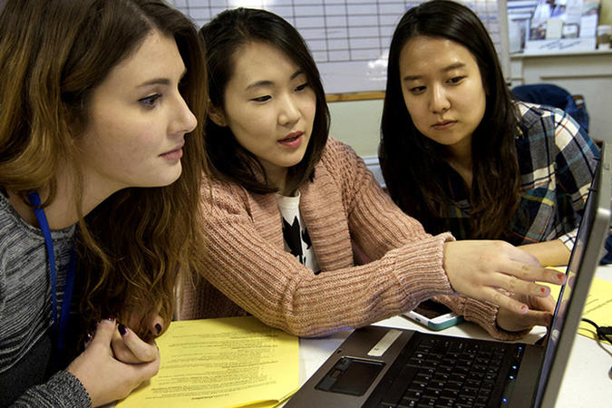 Three students working together at a laptop