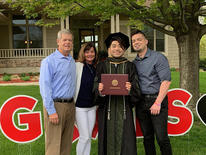 Damian holding diploma at graduation