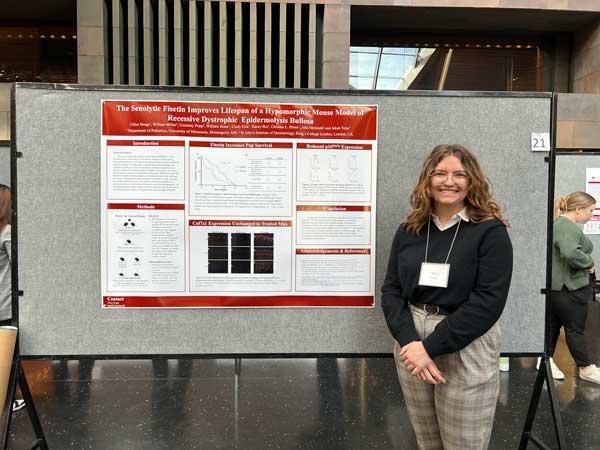 Woman standing in front of her research poster 