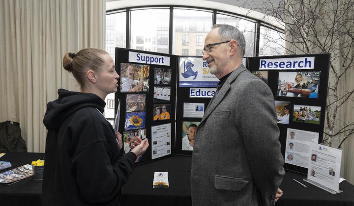 Attendee interacting with a representative from the Rein in Sarcoma Foundation.