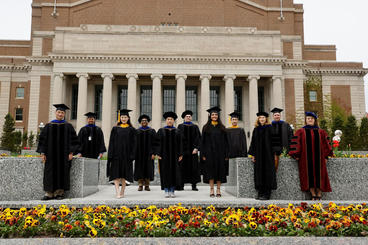 graduates standing in front of building