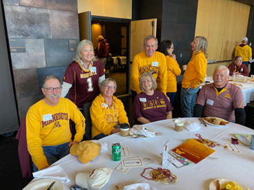 group photo with alumni wearing maroon and gold at homecoming